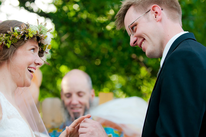 bride and groom exchange rings in backyard ceremony