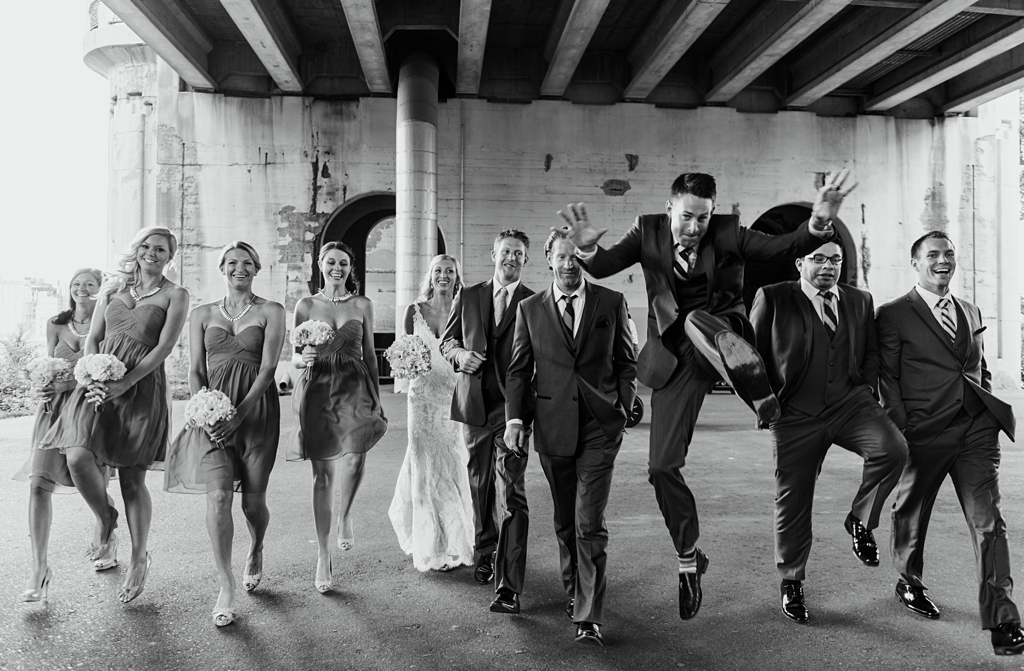 Groomsmen jumps during bridal party portraits at St Anthony main