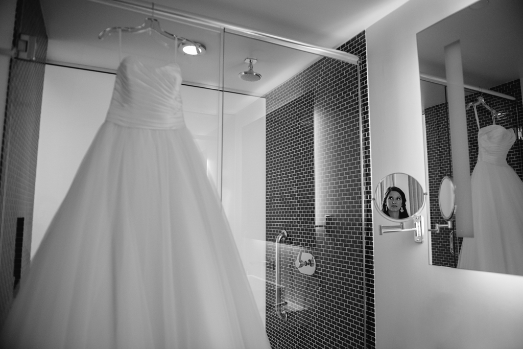 bride's dress hanging up with reflection in mirror