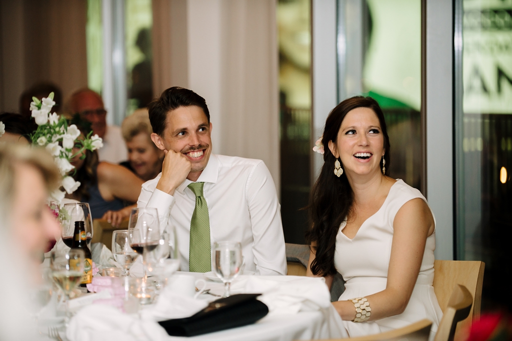 bride and groom listen to wedding reception speeches