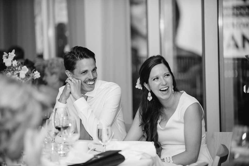 bride and groom laugh during wedding speeches