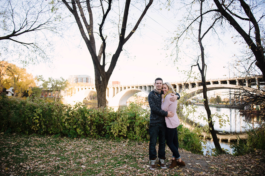 engaged couple hugging in front of mississippi river