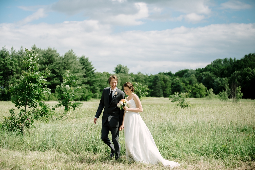 newlyweds in grass field after ceremony