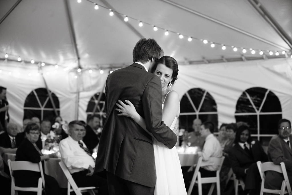 newlyweds share first dance in backyard wedding reception tent