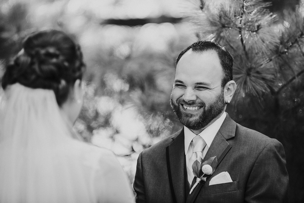 groom smiling at bride during outdoor wedding ceremony