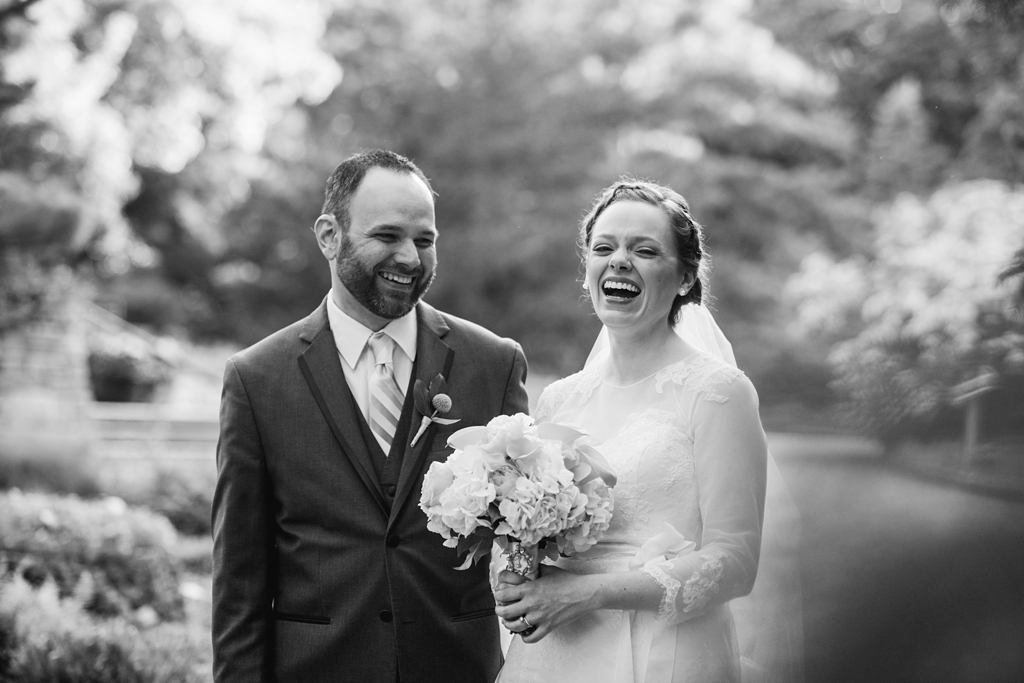 bride and groom laugh during wedding portraits