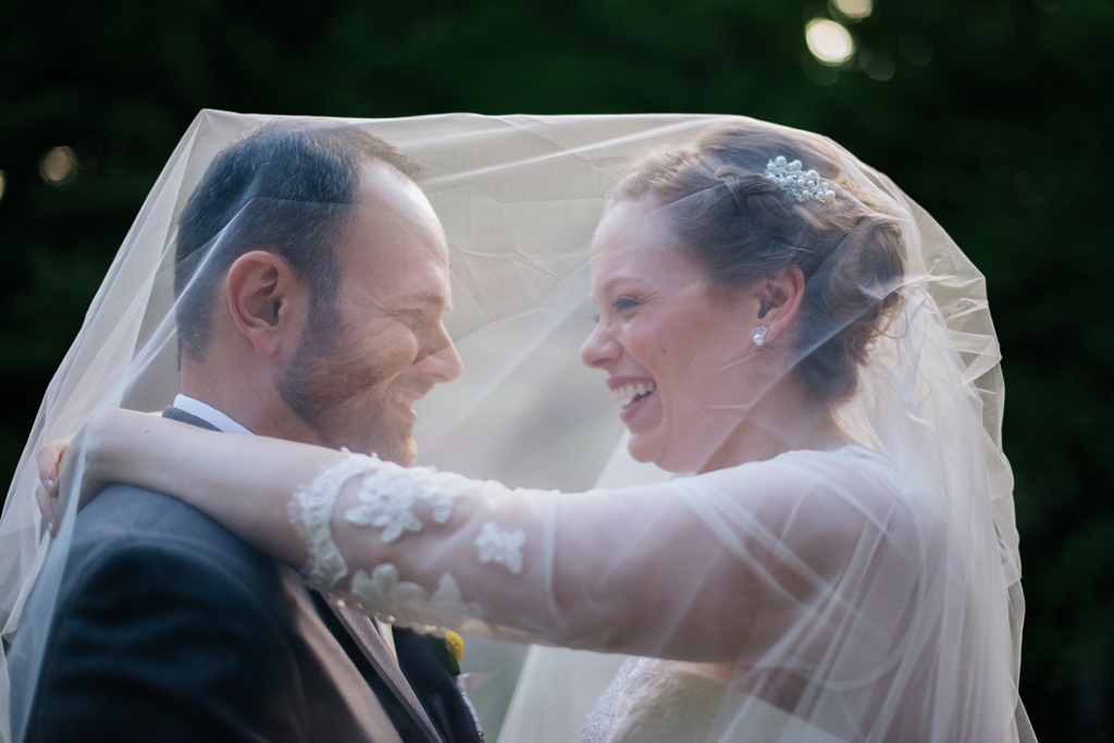 newlyweds both under bride's veil