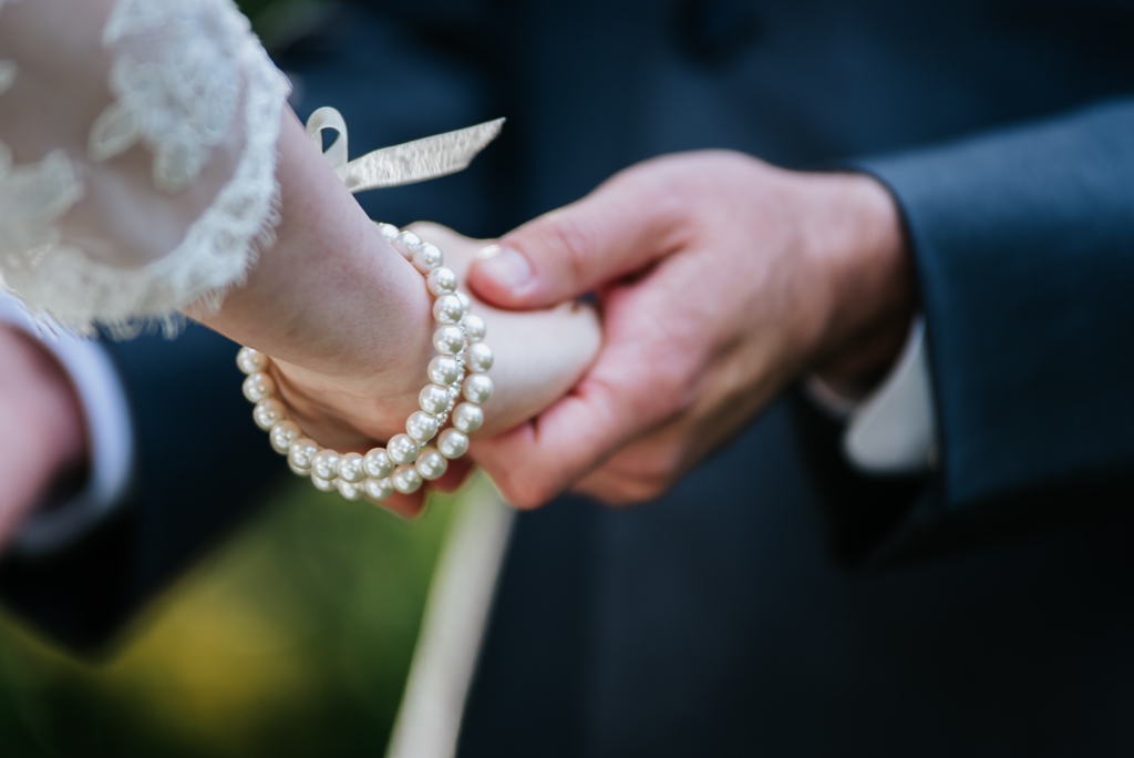 detail of bride and groom holding hands