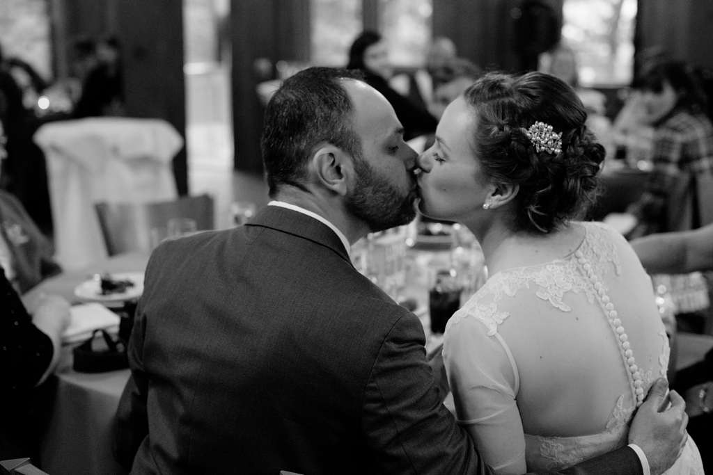 bride and groom kiss at wedding reception