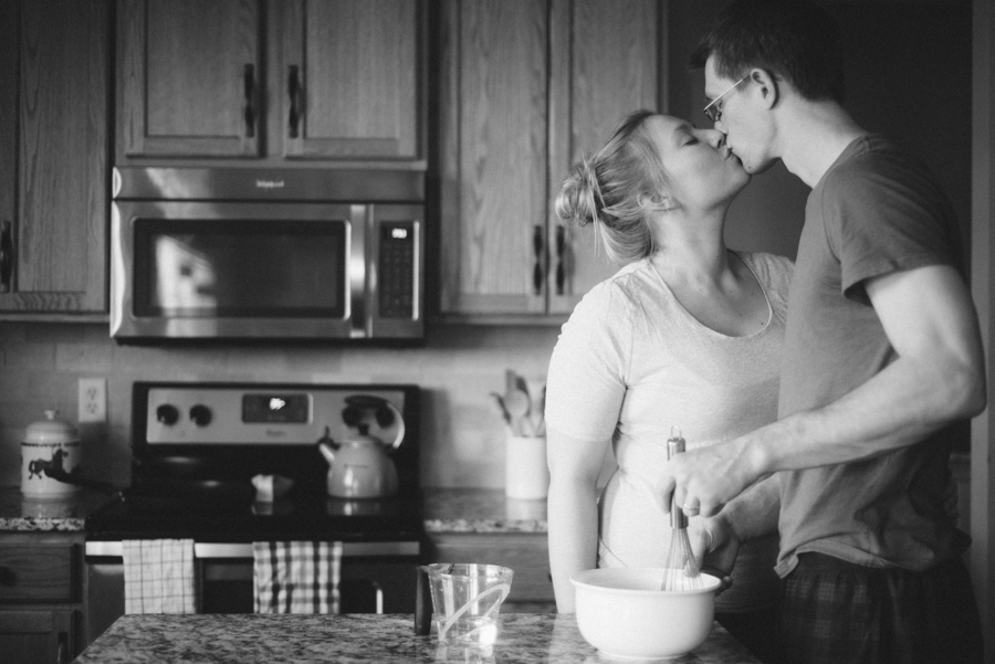 couple making pancakes and kissing in kitchen