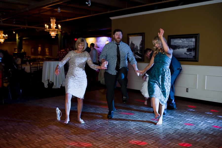 guests kicking off shoes to dance at wedding reception