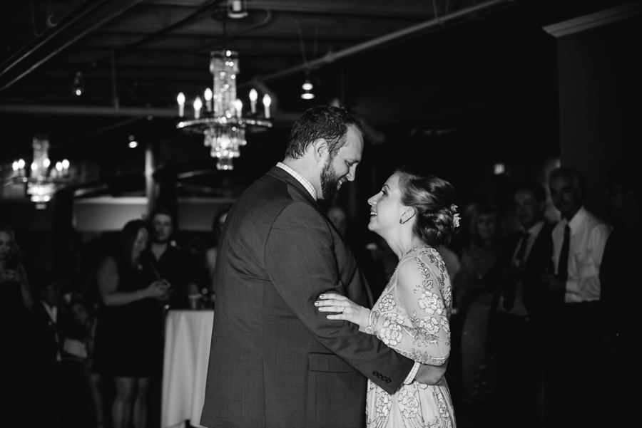black and white image of bride and groom dancing