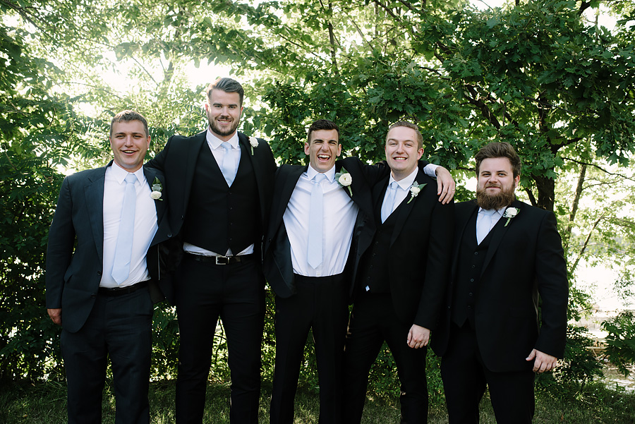 grooms and groomsmen portrait hugging and laughing