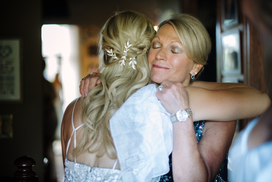 emotional mom of the bride hugging the bride