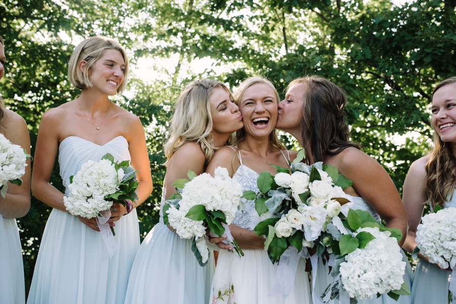 bridesmaids kissing the bride 