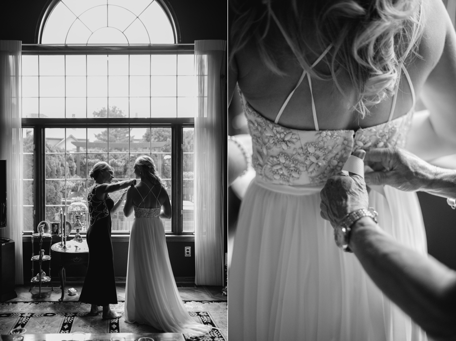 black and white details of bride putting on her dress 