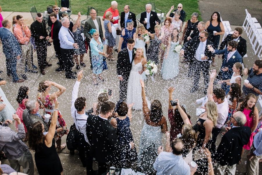 guests throwing confetti over bride and groom 