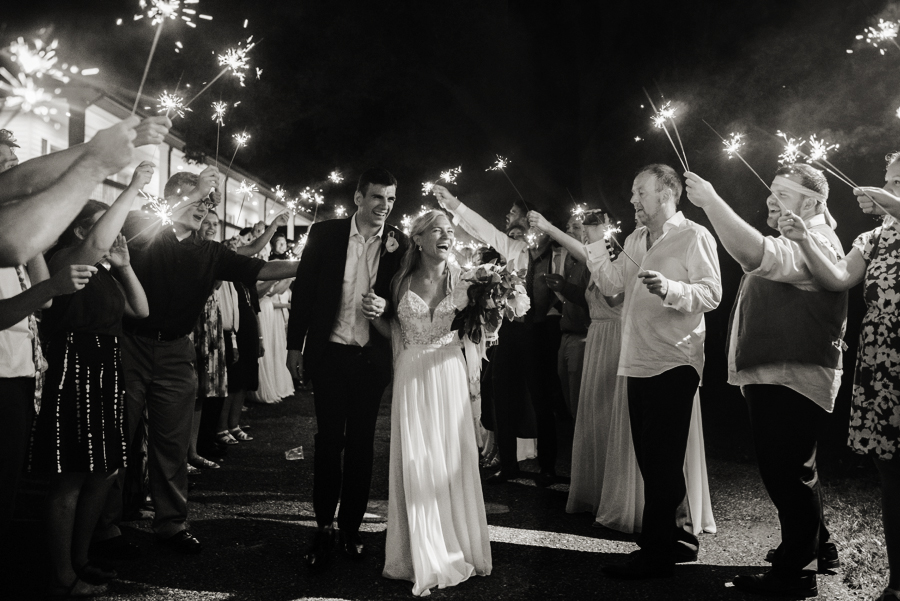 bride and groom leaving reception under sparklers