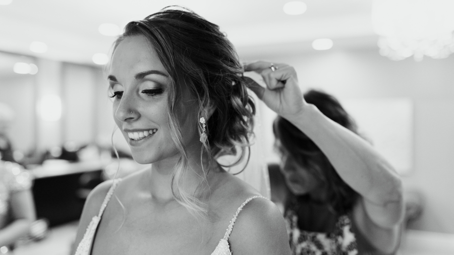 black and white photo of finishing touches on bride's hair