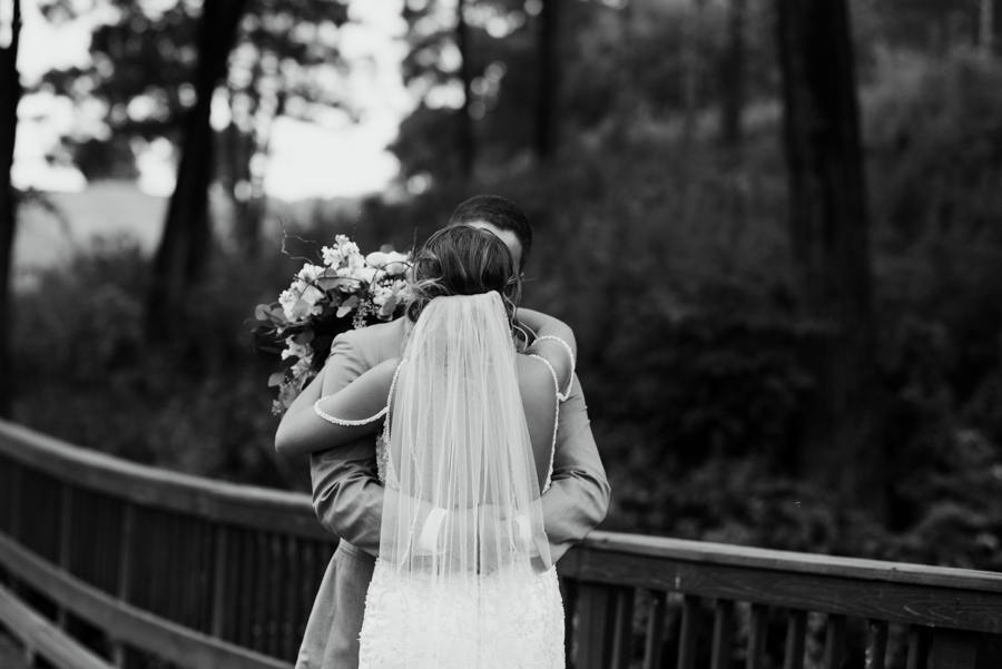 black and white photograph of bride and groom kissing
