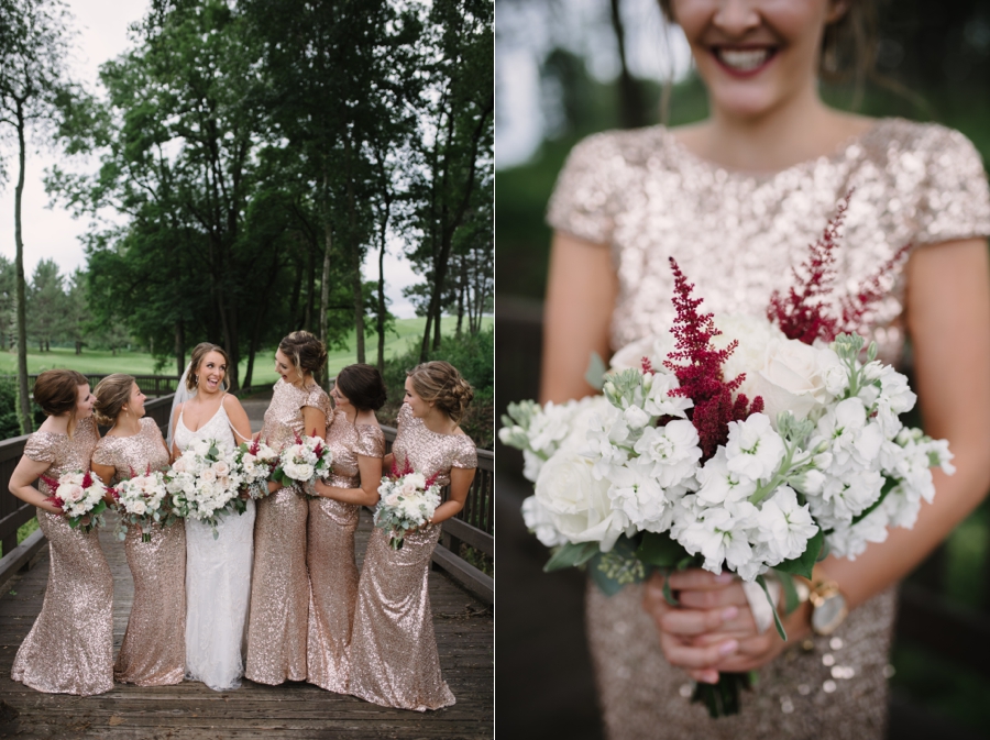 bridesmaids and bride holding white bouquets with red accents on bridge