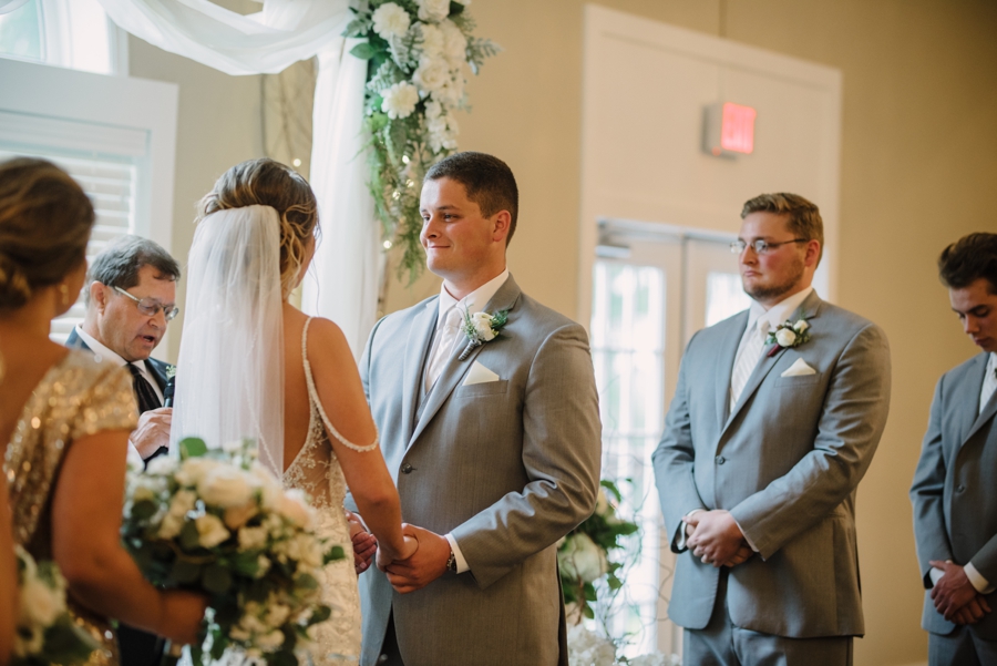 groomsmen looking on at bride and groom during ceremony