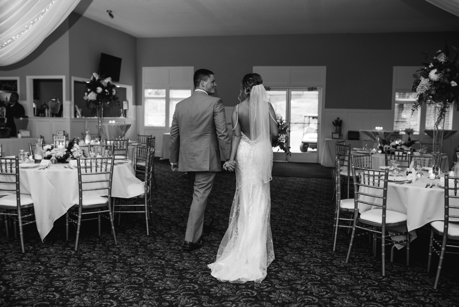 bride and groom walking through reception area before guest arrive