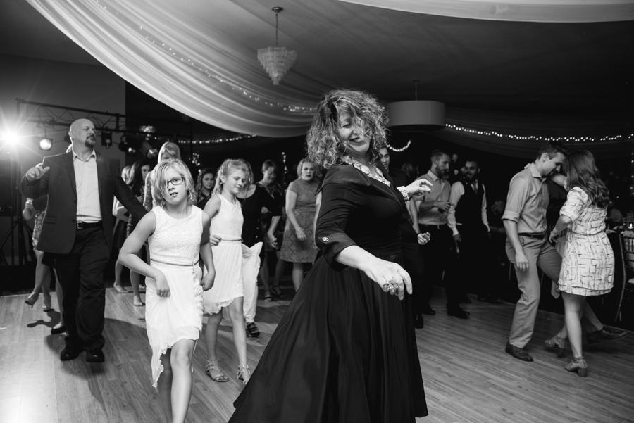 black and white of guests dancing at wedding reception 