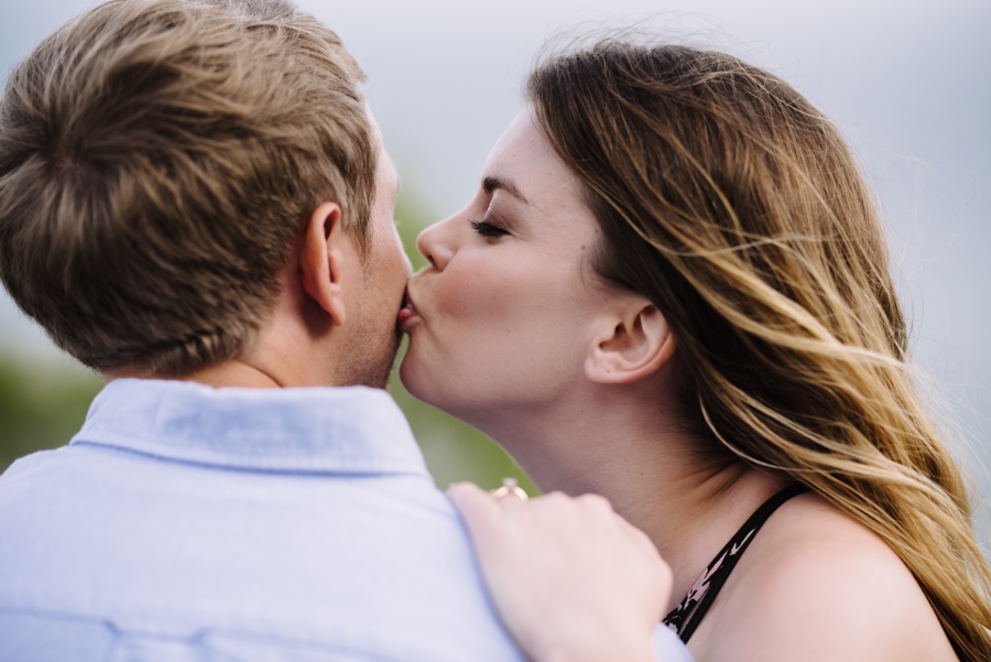 woman kisses man's cheek during engagement session