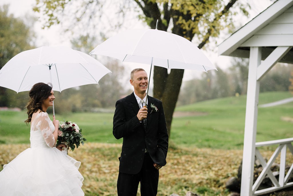 bride and groom with umbrellas during MN outdoor first look