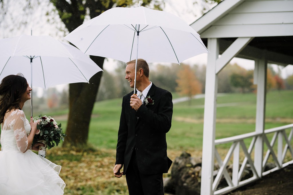 groom reacts during Minnesota rainy first look