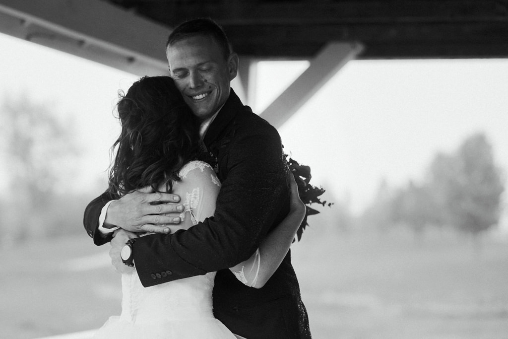 bride and groom holding each other happily during couple photos