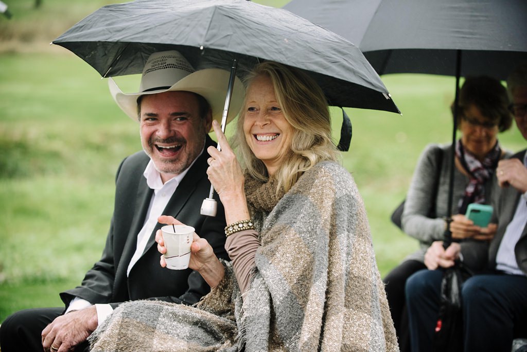Candid guest portraits during MN outdoor rainy wedding