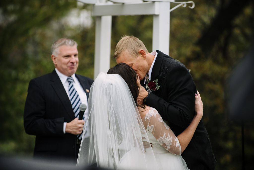 bride and groom kiss during outdoor MN wedding