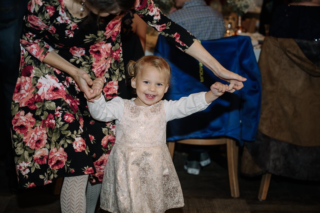 Girl dances holding her moms hands during MN wedding reception