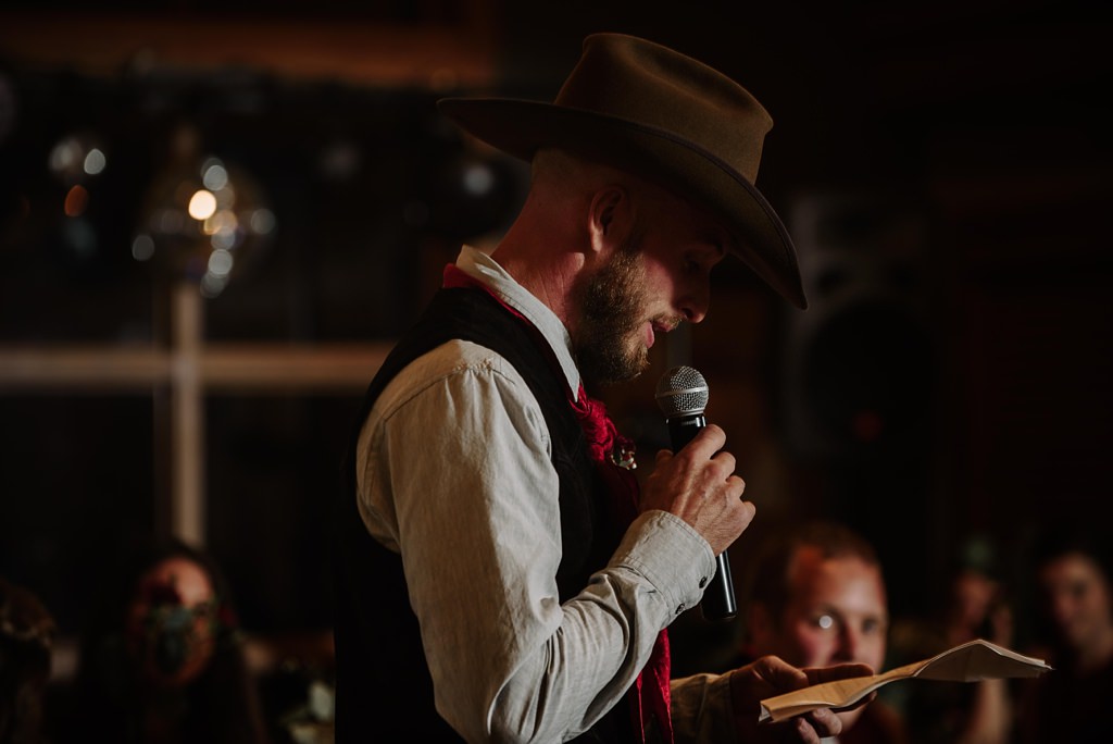 cowboy hat wearing groomsmen giving a speech