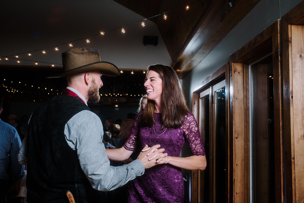 Candid photo of Wedding reception guests dancing and smiling