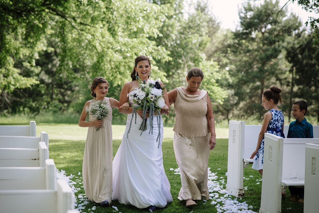 Bride walking in the aisle with mother and daughter