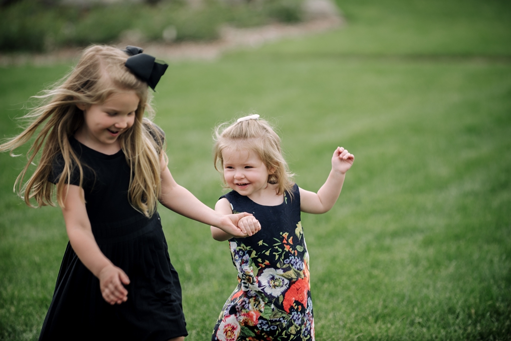 girls playing in grass at outdoor wedding