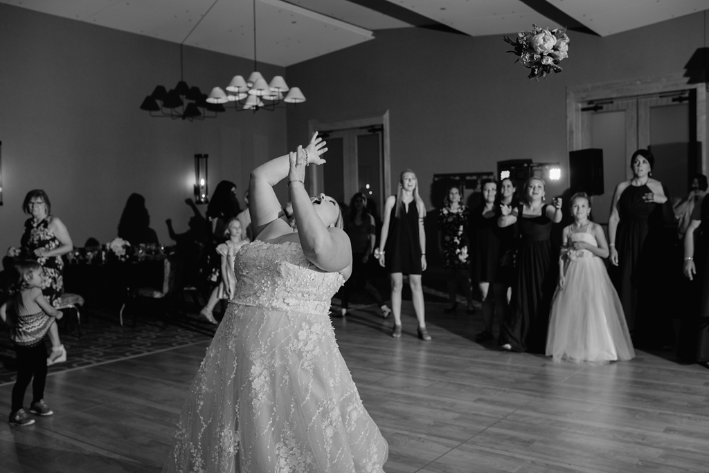bride tossing bouquet at reception