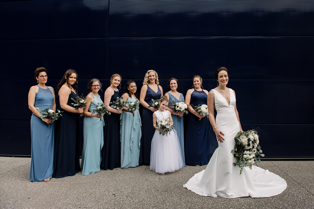 bridal party and flower girl pose outside together