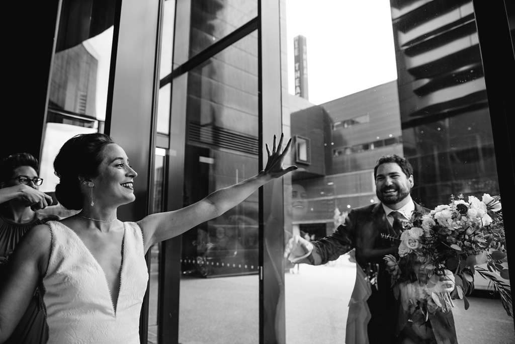 bride and groom see each other through window