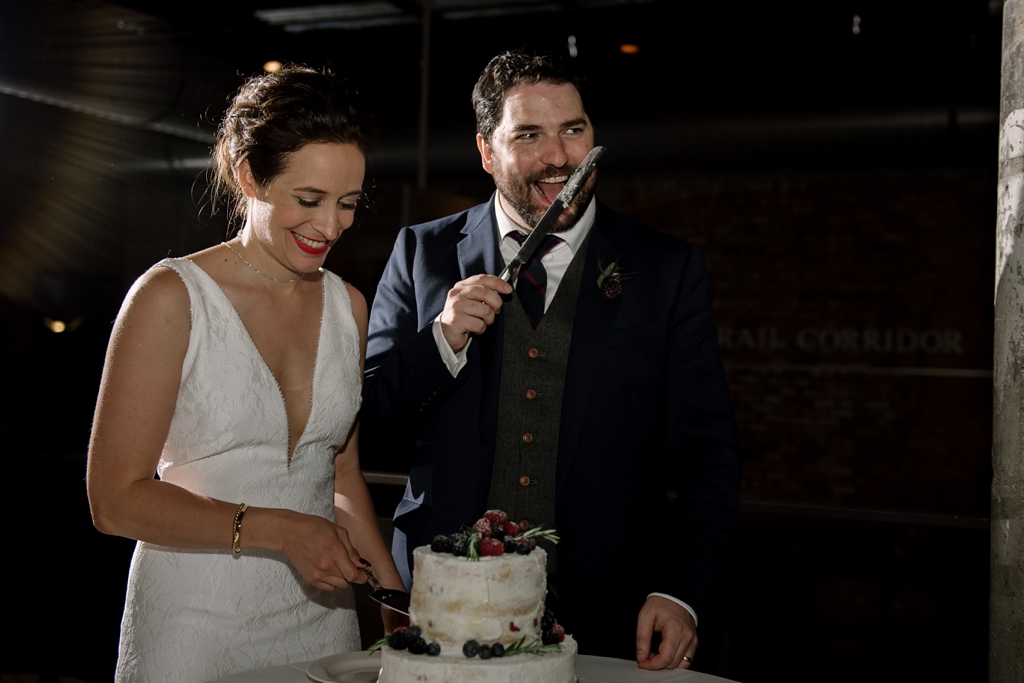 groom licks knife after cutting cake
