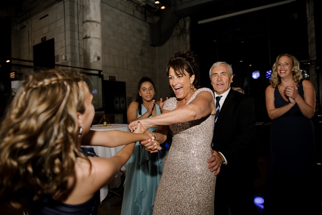 mother of bride dances with guest at wedding reception