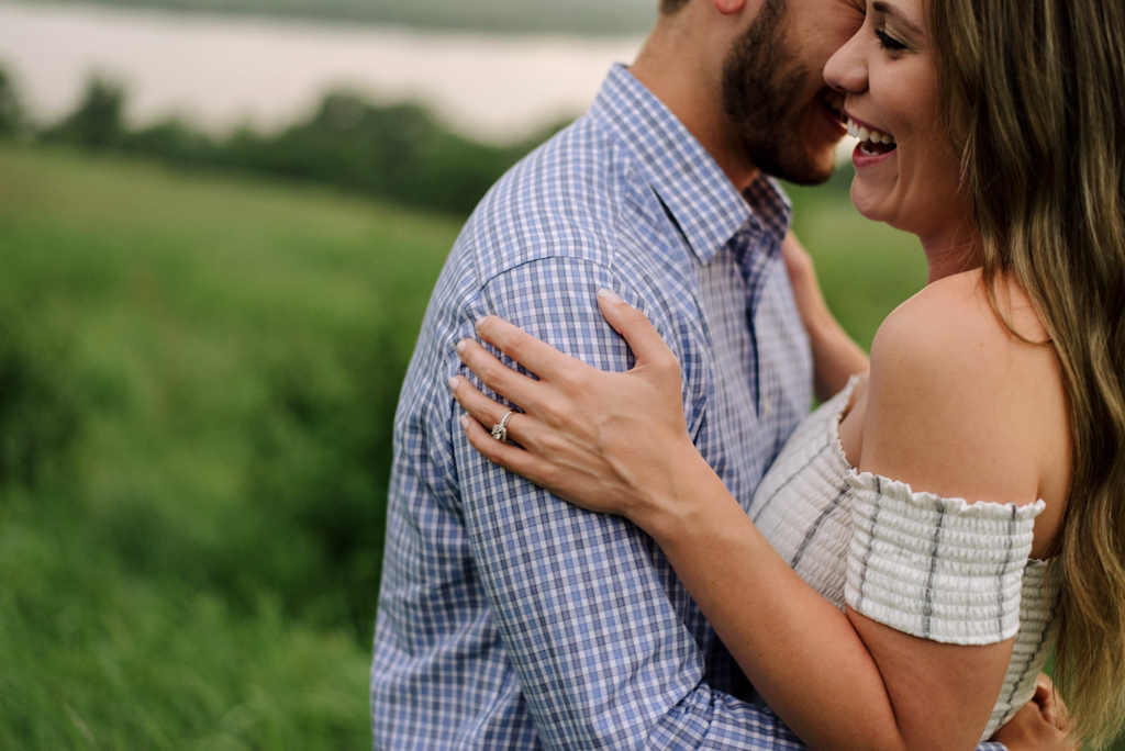 engaged couple embracing in green field in minnesota