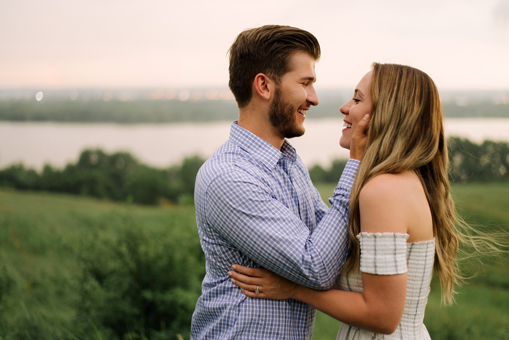 embracing couple in minnesota field by river