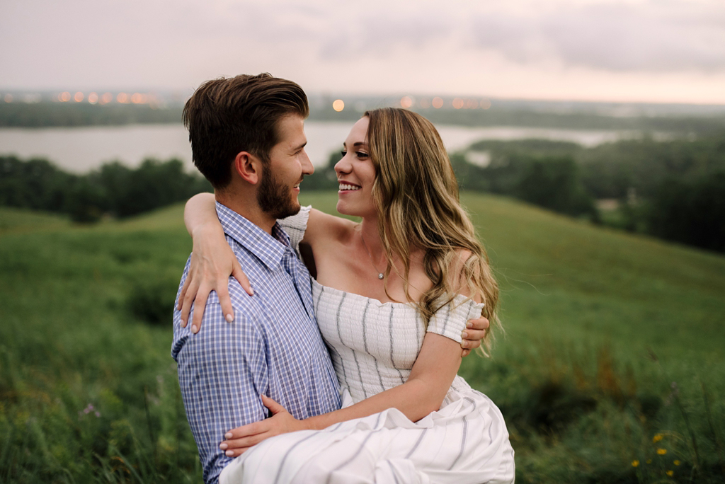 engaged couple cuddling in prairie twin cities