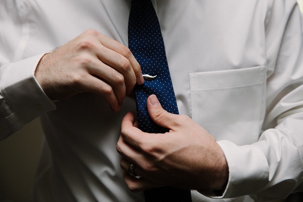 groom putting on whale tie clip