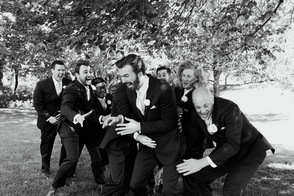 groomsmen pretend to tackle groom