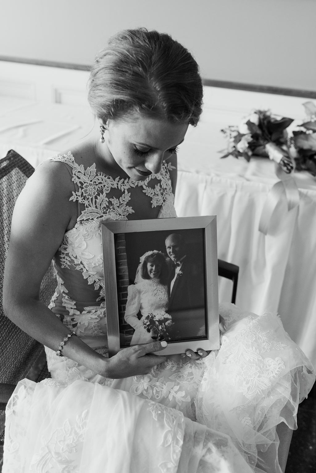 bride holds photo of parents at wedding